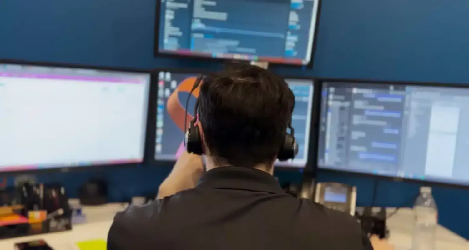 An NBIT engineer monitoring client systems across a wall of screens